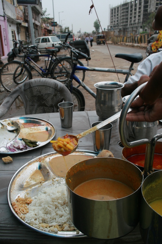 India, Rajistan, Jaipur - 15 Ruppees (US$0.45), all you can eat Rice Dal - aka Rice, Lentals, Veg curry. Sure, sometimes to get 