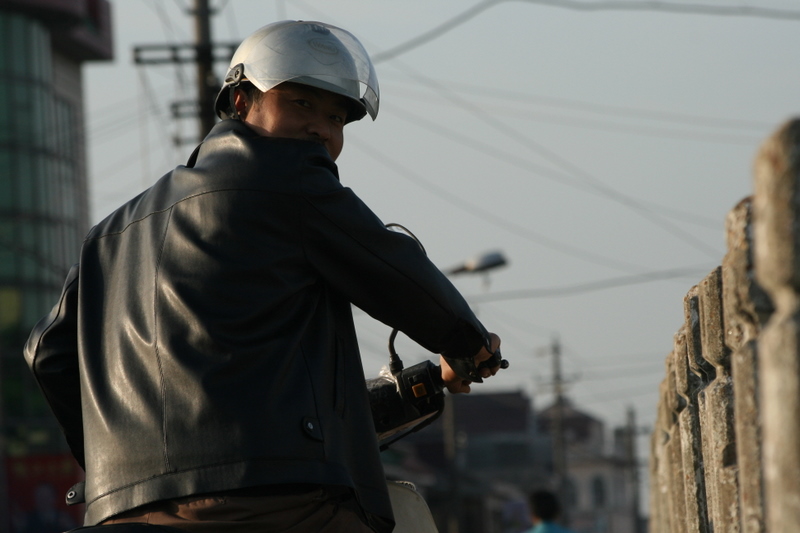 Oct 9 2007 - Changrong village, Jiangsu Prov, China. Morning on the street. A motorcyclist stops to look.