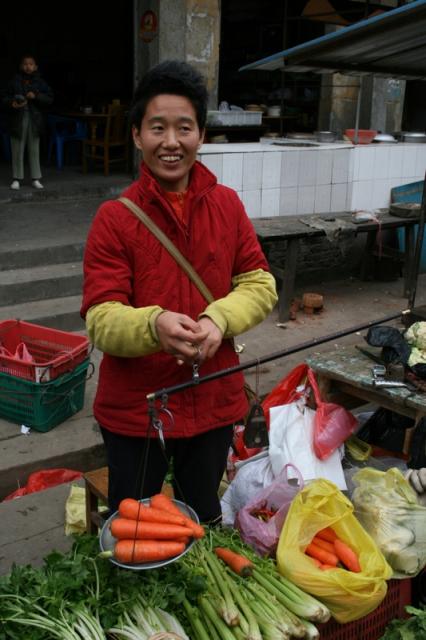 Da Qiao, Guangdong - Buying carrots from a street vendor. She is using a typical Chinese scale. Though the arm is supposed to be