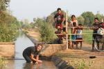 Lao - Adam bathing in the irrigation ditch with an audience