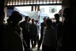 China, Guangxi Prov - A crowd gathers in the doorway of our lunch restaurant, curious about the foreigners who've arrived on bic