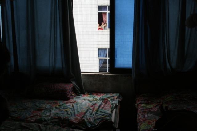 China, Guangxi Prov - kids looking into our guesthouse room from across the way 3 stories up