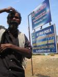 A curious onlooker observing the disability camp stands next to SCORD's sign.