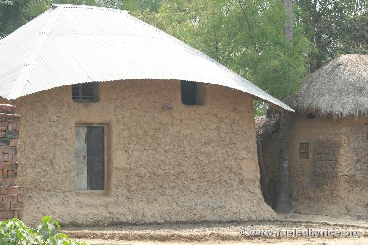 India, West Bengal - Village houses constructed out of mud and thatched roofing with the occasional corrugated metal roof.