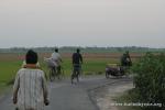 India, West Bengal - A few locals trail Drew and the Bandwagon on a beautiful back county road