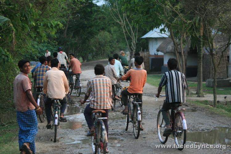 India, West Bengal - Curious locals following and gathering around us as we stop to ask a Catholic Mission if its possible for u