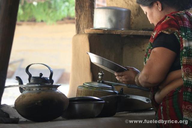 Nepal, west lowlands, Amiliya - The head cook with her wood-fired mud stove. The "Best Restaurant" in the village, acc