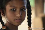 Nepal, west lowlands, Amiliya village - The cook's daughter and the wood-fired mud stove behind at the best restaurant hut in th