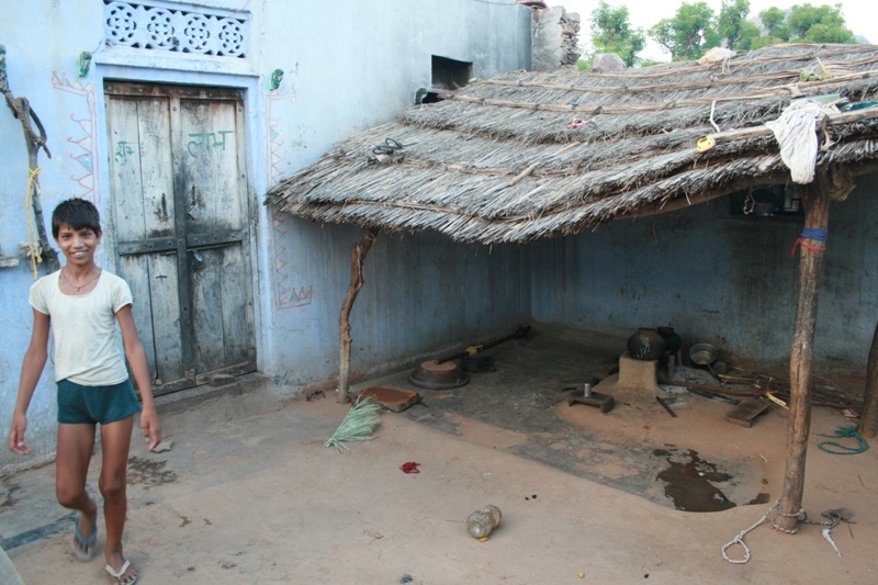 India, Rajistani village - (Drew)- Boy with kitchen in background.  At the home where we stayed for one night when villagers fou