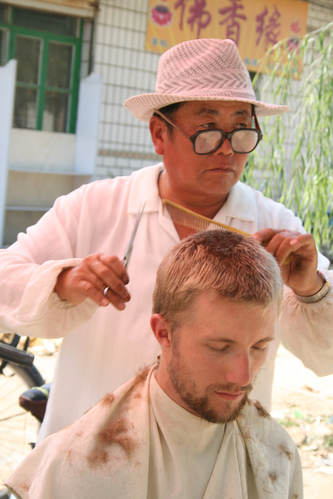 China - Drew getting a haircut at a morning market