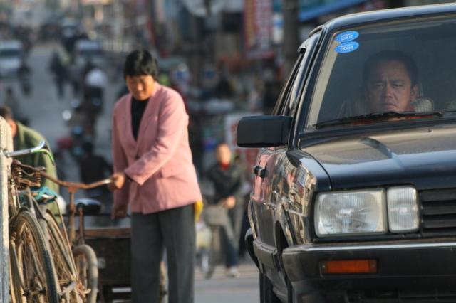 Oct 9 2007 - Changrong village, Jiangsu Prov, China. Morning on the street. The constant tension between cars, bikes, and pedist