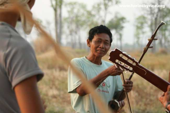 Cambodia - Camping in back of family Sre's included a music concert. One of the neighbors attracted by the sound asked to play P