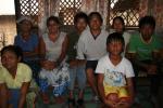 Nepal, Bhutanese Refugee Camp - Mouikumar (white R off cen) and his family in his living room