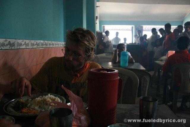 India, West Bengal - (Drew eating lunch) A crowd gathers in the rural restaurant where we are eating, curious about us and our f