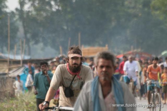 India, West Bengal - Jim riding away from a small market crowd that gathered around us when we stopped for a rest along a small
