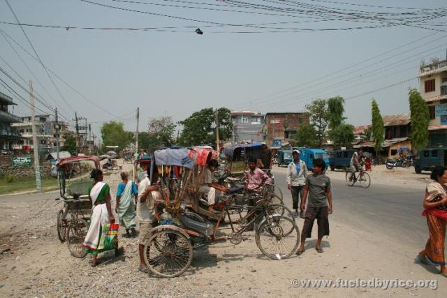 Nepal, east lowlands - Typical street scene in Nepali/India market town. Pedicabs waiting and ready, three-wheeled home-made typ